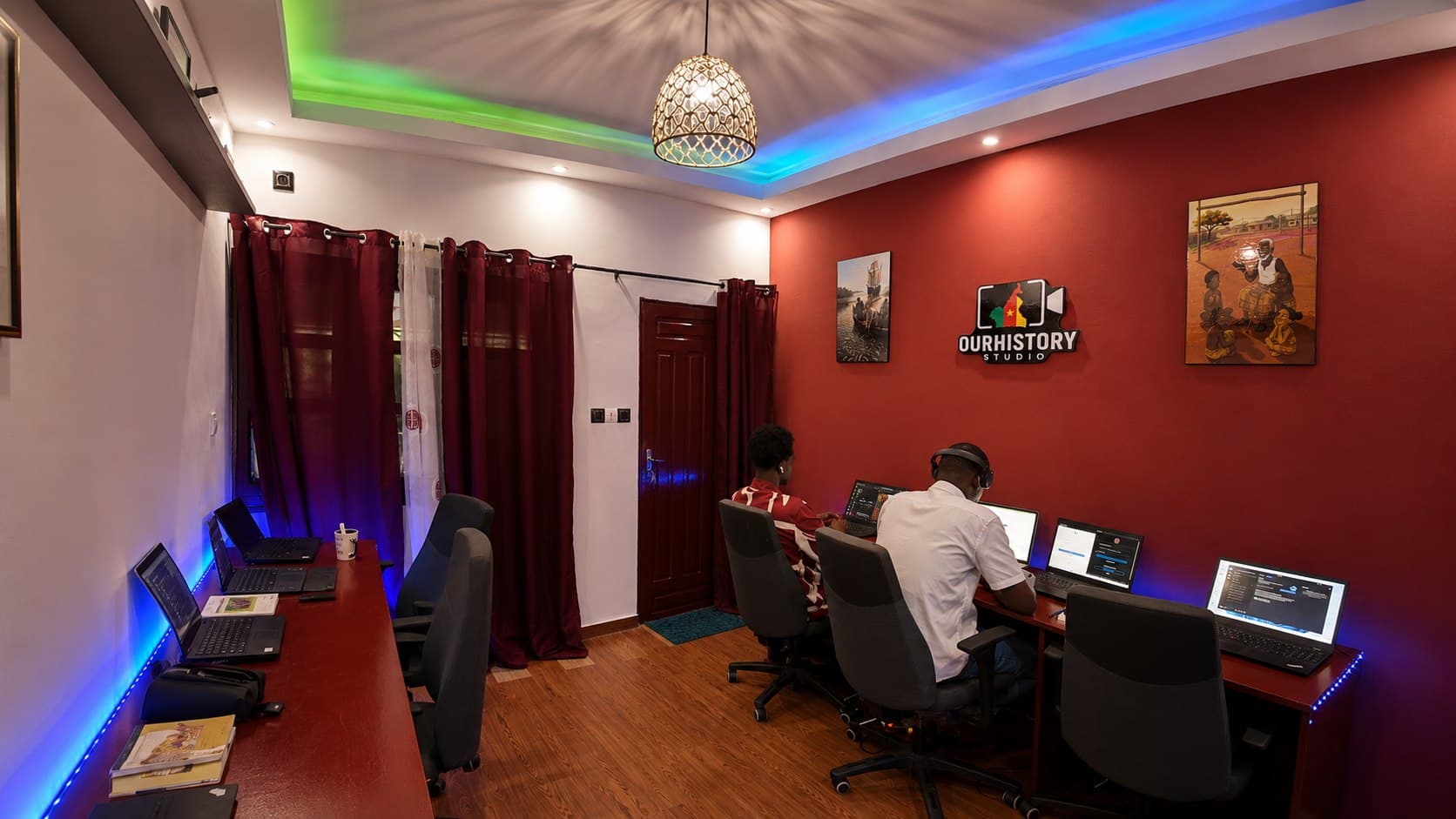 Vue large de l'espace OurHistory Studio à Douala avec deux participants au travail sur ordinateur.